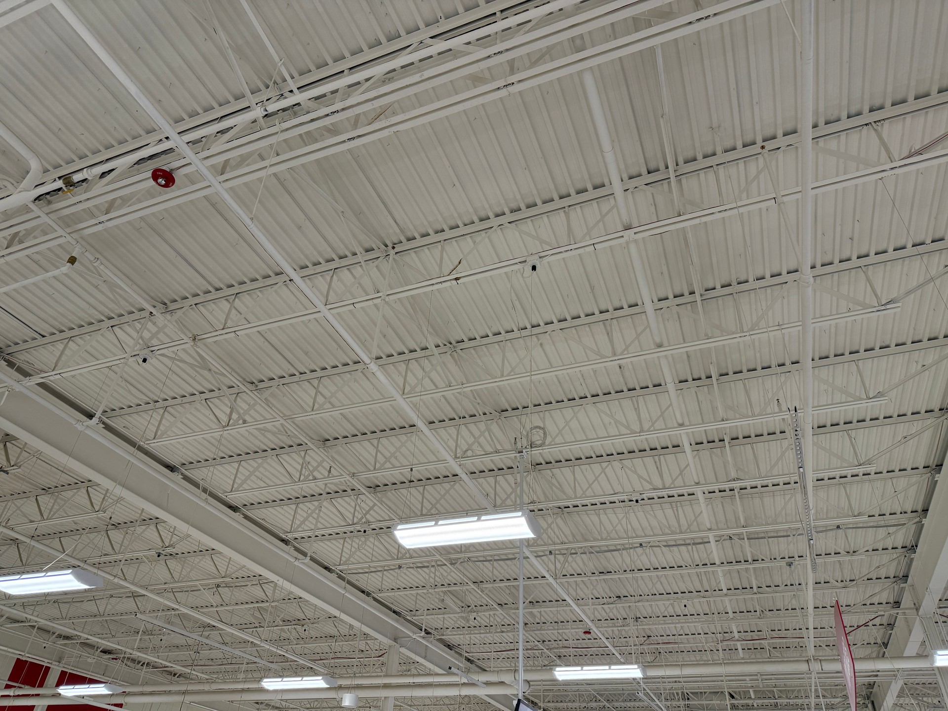 Ceiling with bright lights in a modern warehouse, shopping center building, office or other commercial real estate object. Directional LED lights on rails under the ceiling